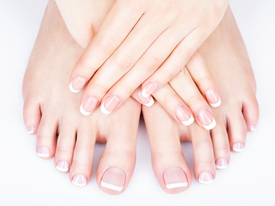 Closeup photo of a female feet with white french pedicure on nails. at spa salon. Legs care concept
